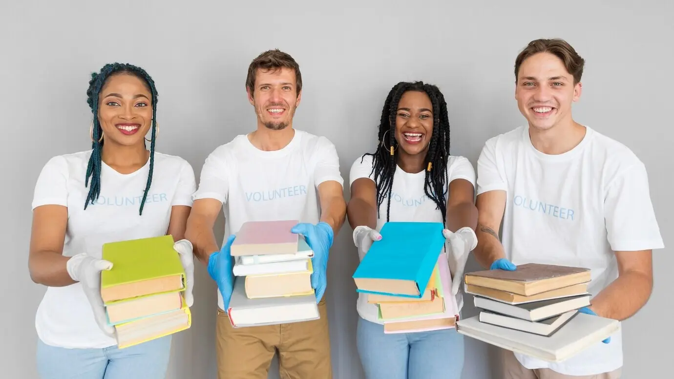 Lächelnde Menschen halten einen Stapel Bücher, um sie zu spenden.